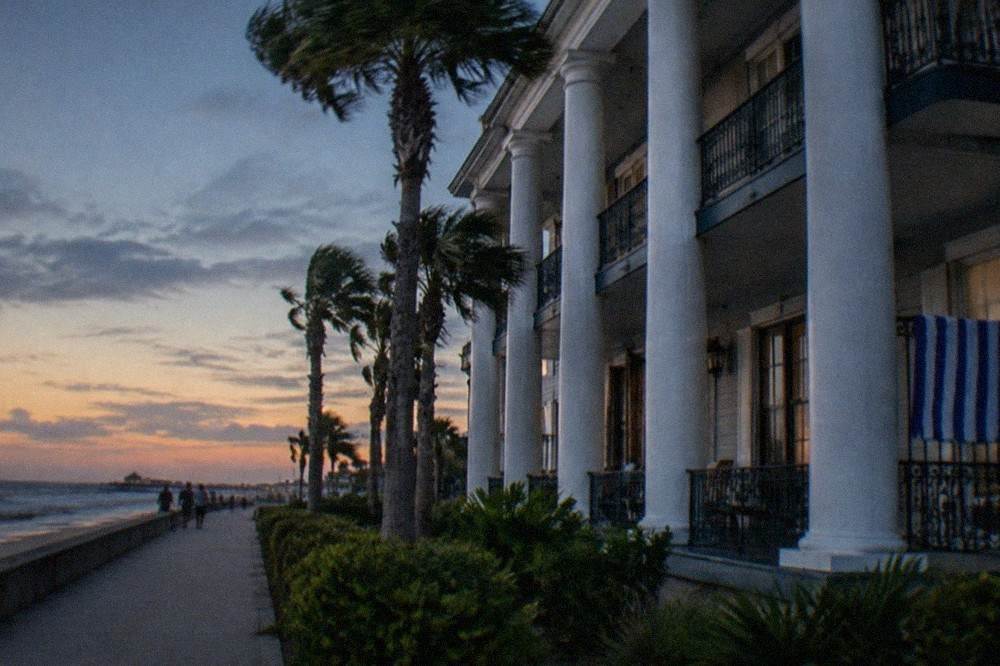 Grand hotel exterior with white columns and balconies facing the seawall