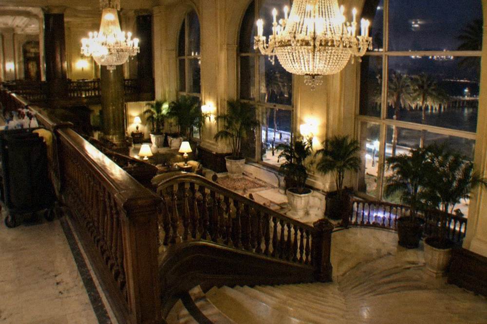 Ornate hotel lobby with chandeliers and a grand staircase