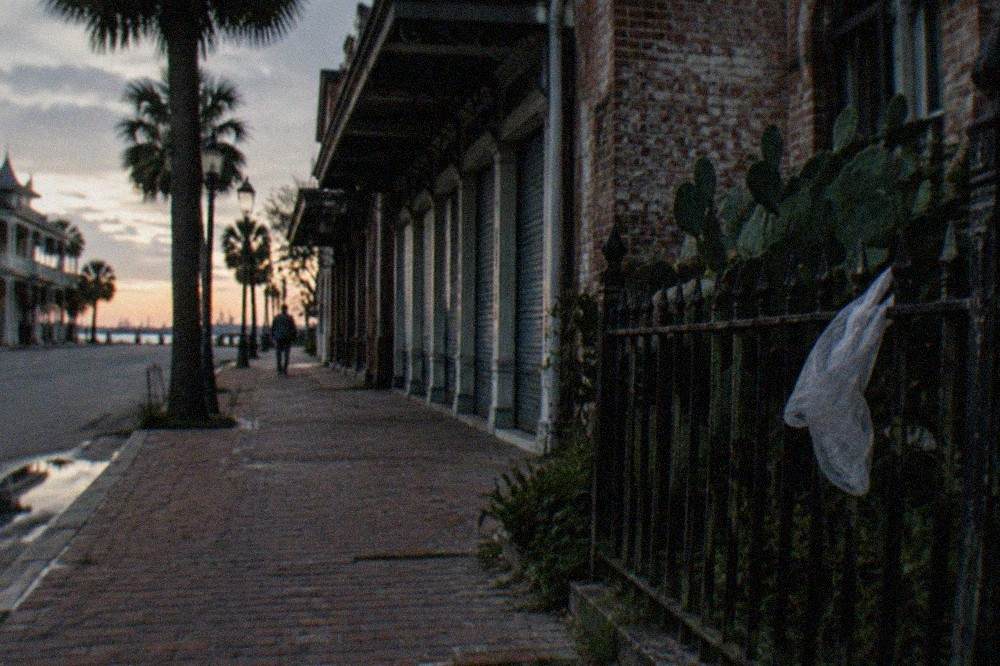 Old brick storefronts on a quiet Galveston street at dusk