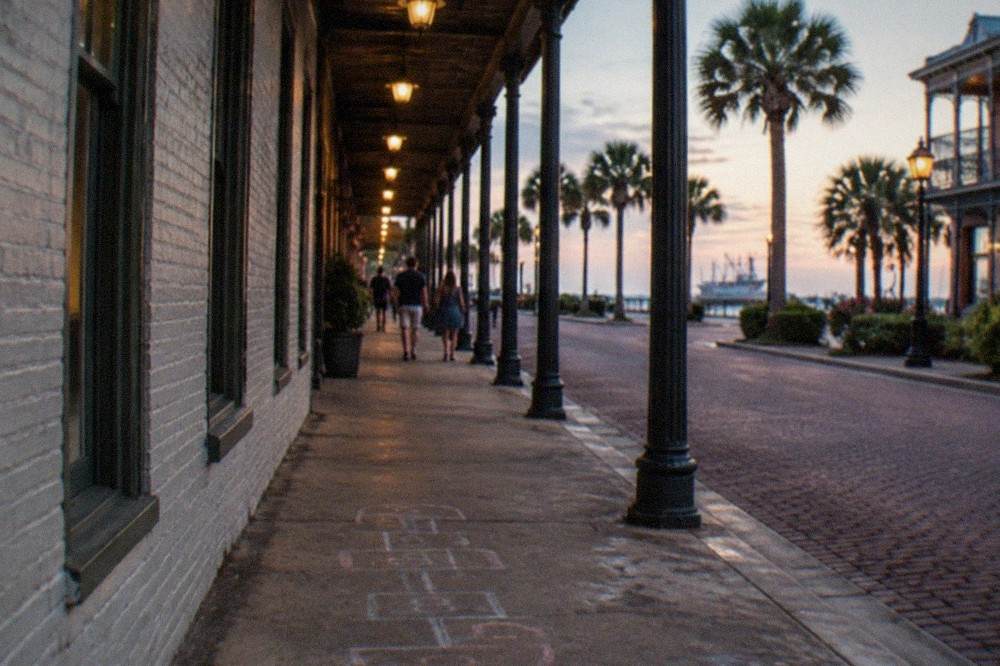 Historic brick buildings on a downtown street lit by warm lamps in the evening