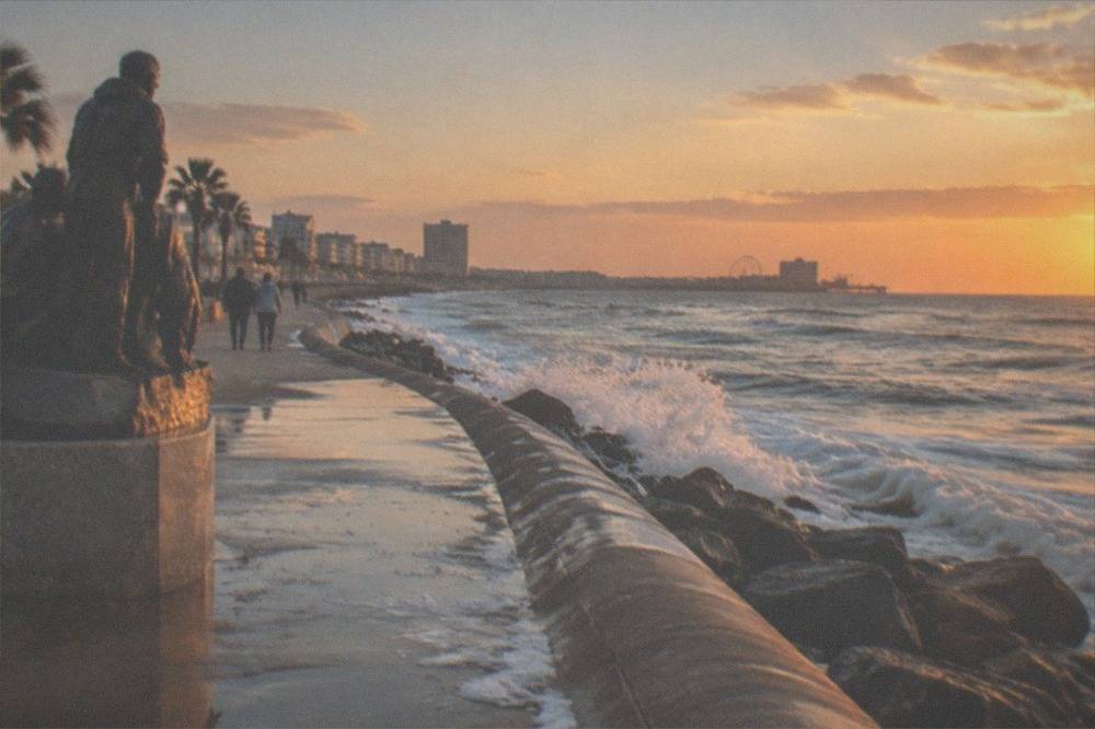 The Galveston Seawall curving along the Gulf at golden hour with waves against the rocks