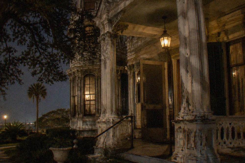 Lit Victorian mansion facade on Broadway at night
