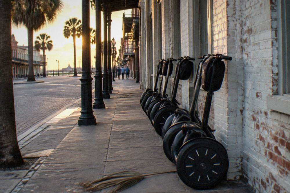 A row of parked segways on a Galveston sidewalk in the late afternoon
