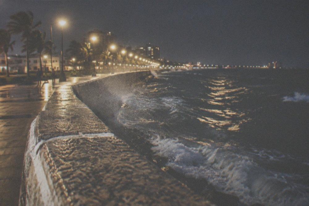 The Galveston seawall curving along the dark Gulf horizon under evening sky