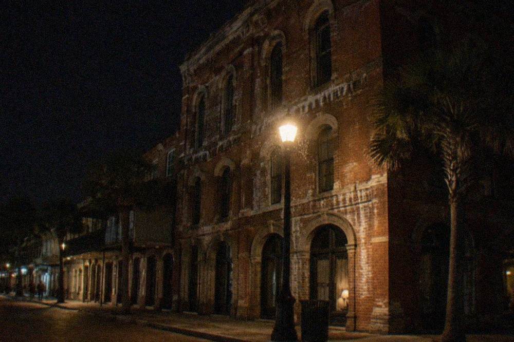 A Victorian brick building facade lit by a street lamp at night